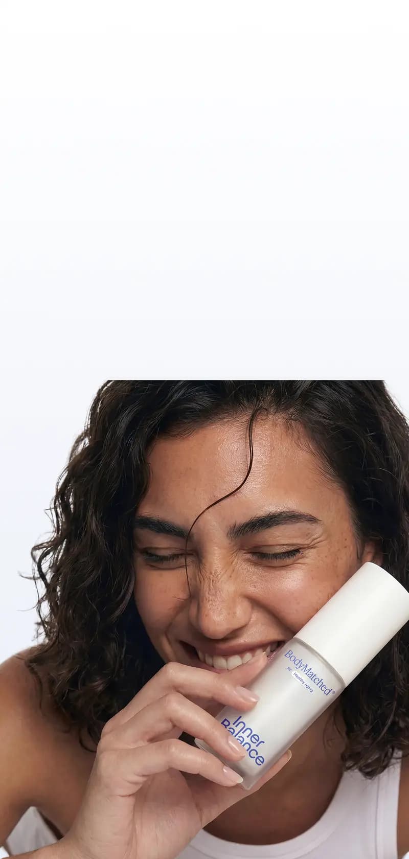 Woman holding BodyMatched® face cream with finasteride