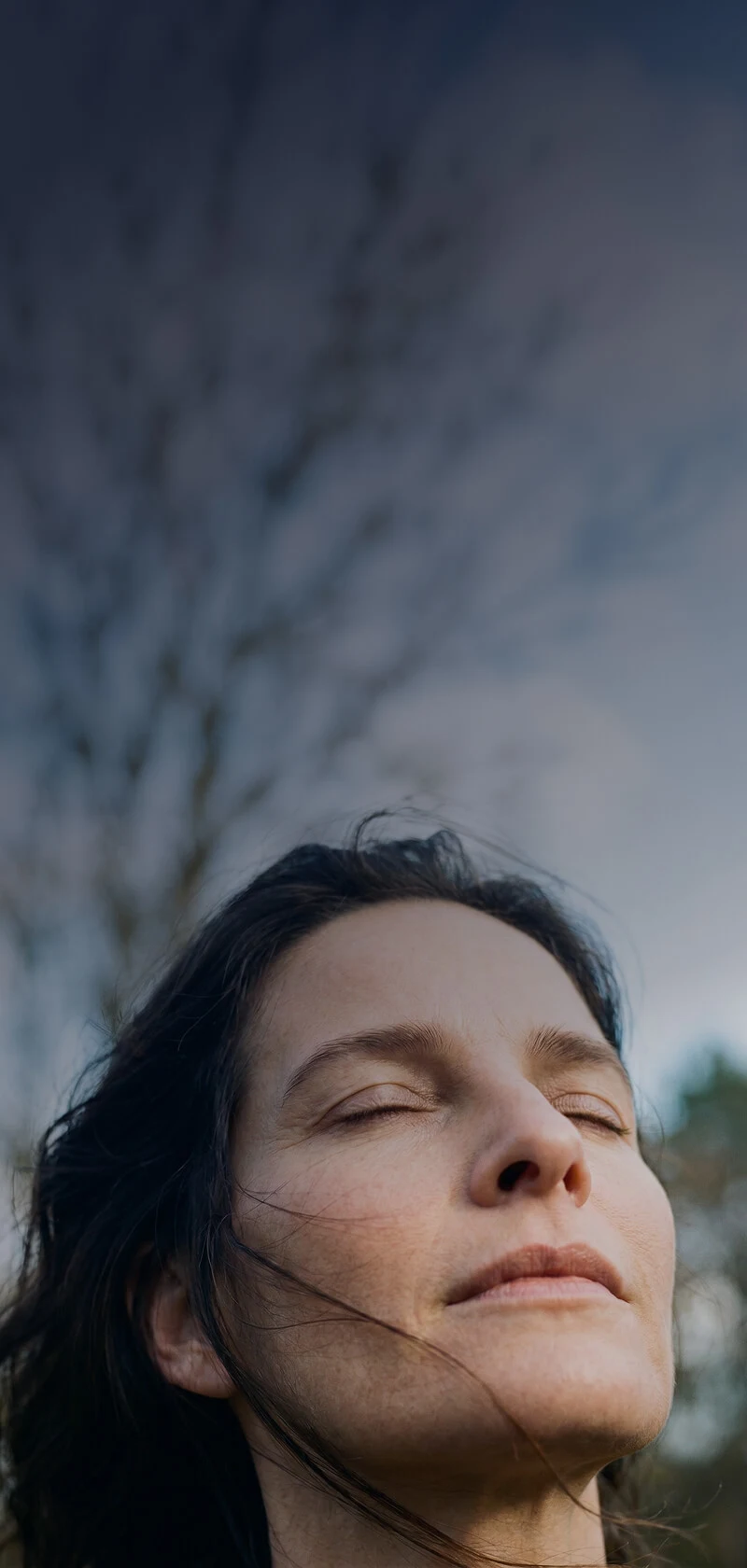 Woman experiencing perimenopause symptoms with eyes closed