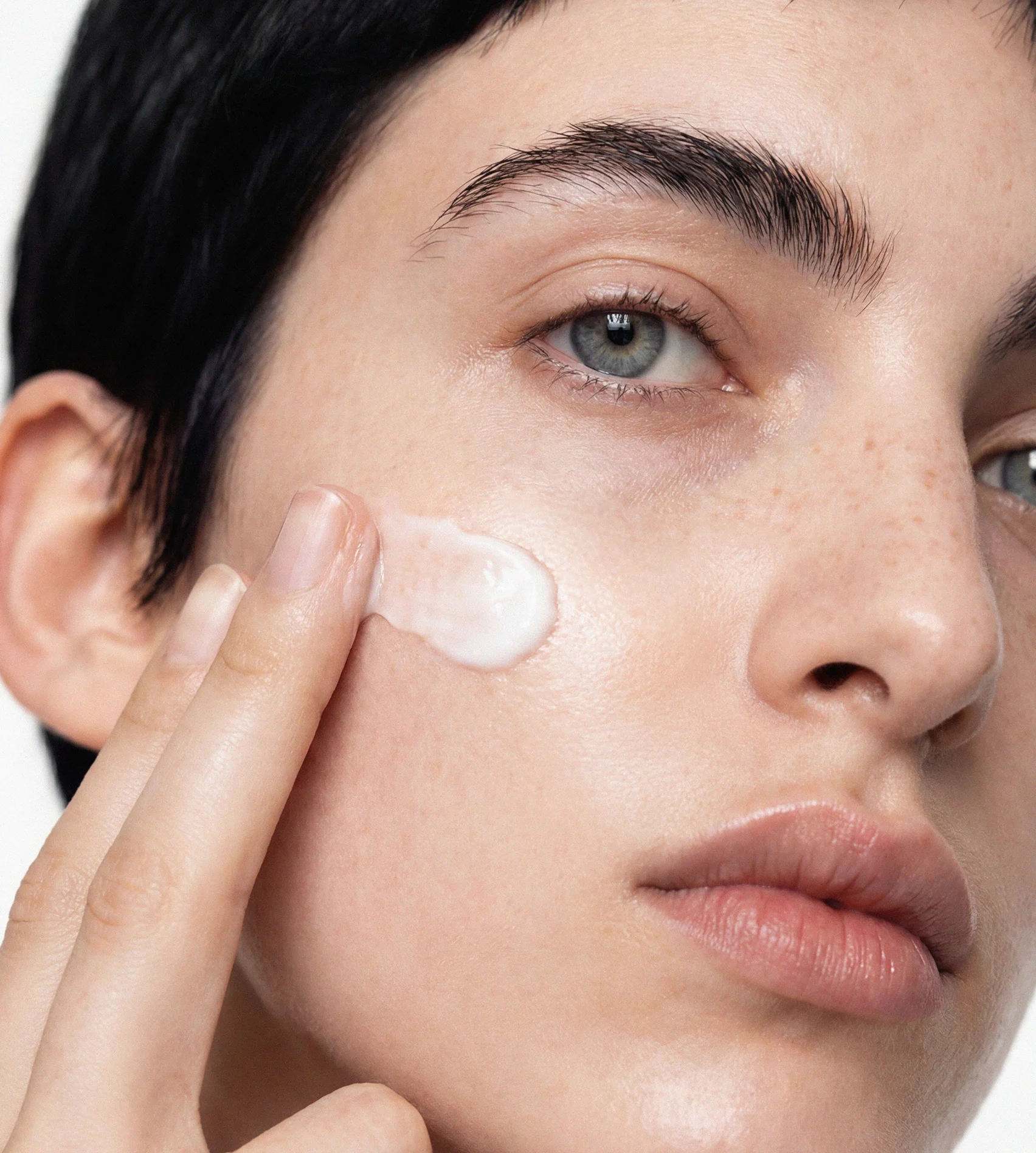 Woman applying BodyMatched cream to her face