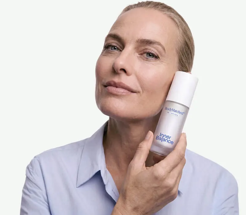 Woman in perimenopause holding BodyMatched® anti-aging face cream