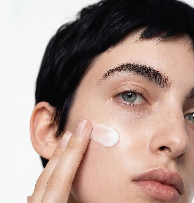 Woman in perimenopause holding BodyMatched® anti-aging face cream