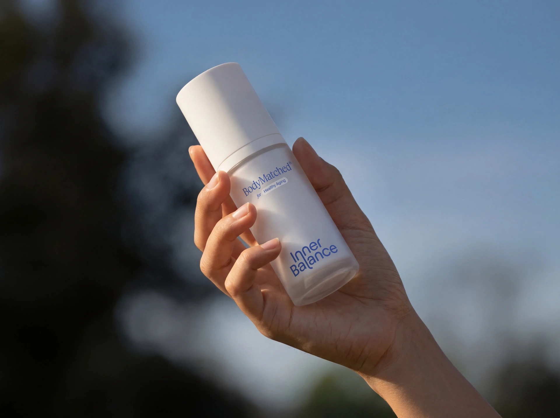 Hand holding a bottle of BodyMatched® face cream