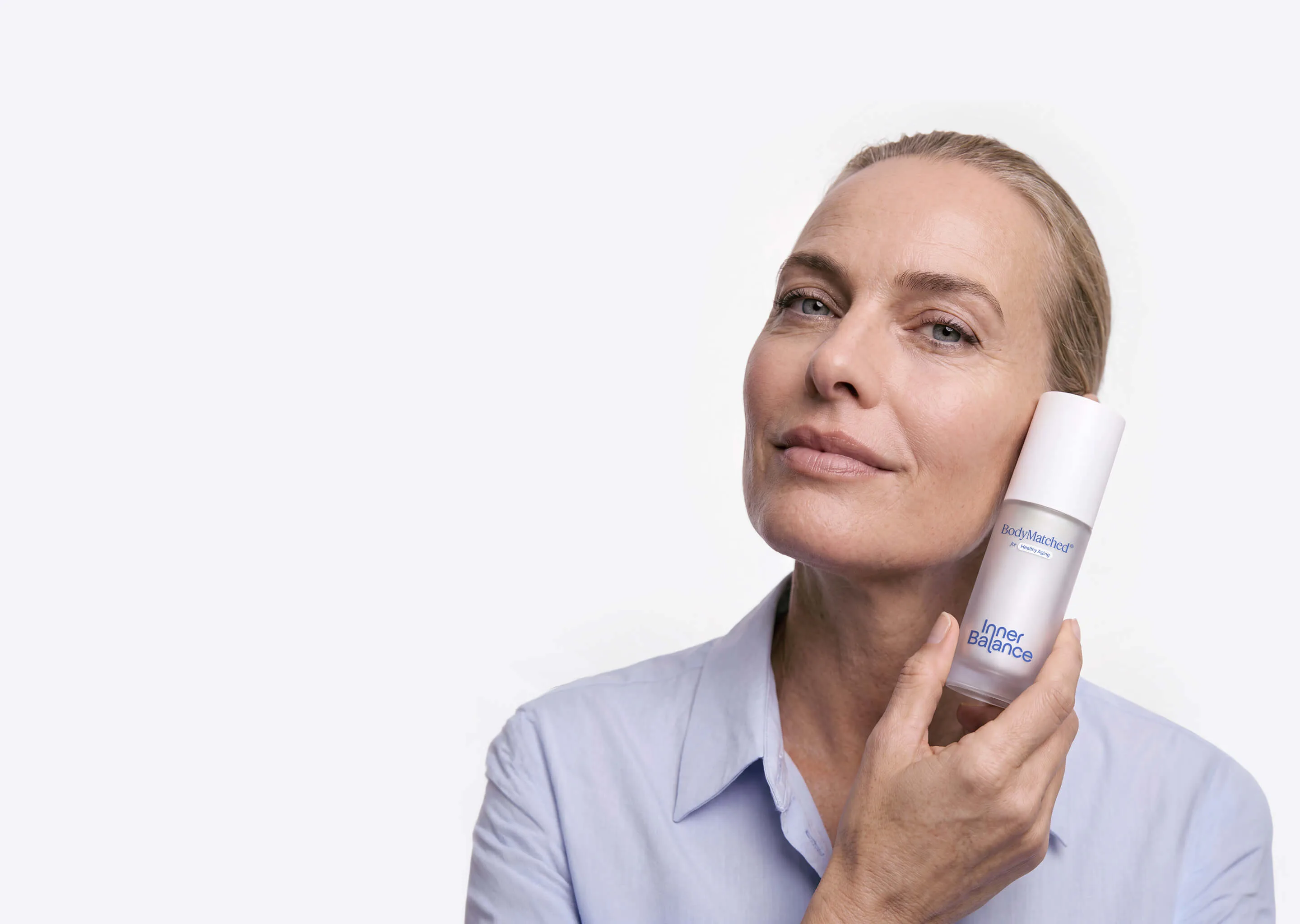 Woman in perimenopause holding BodyMatched® anti-aging face cream