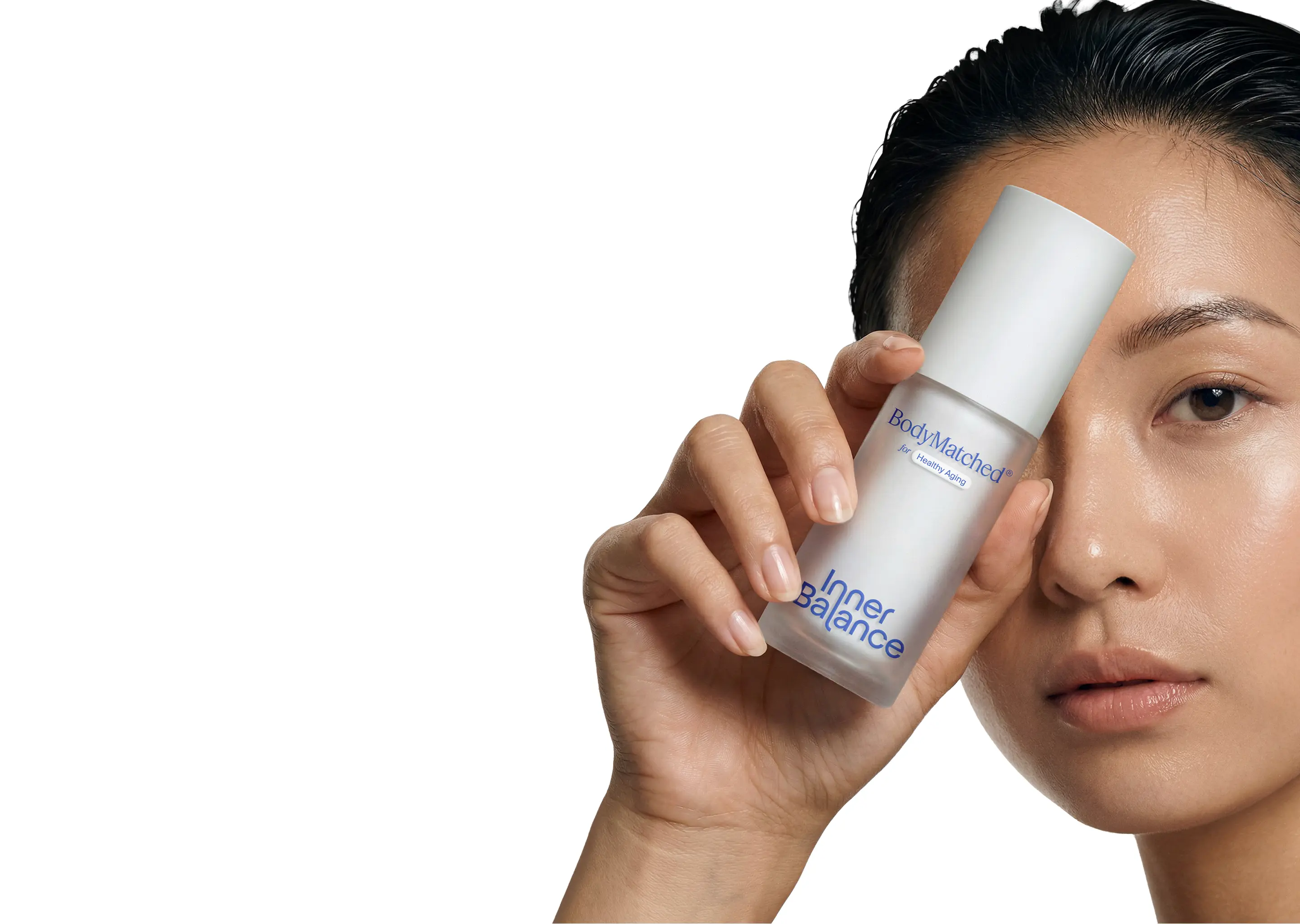 Woman holding BodyMatched® niacinamide face cream to her face