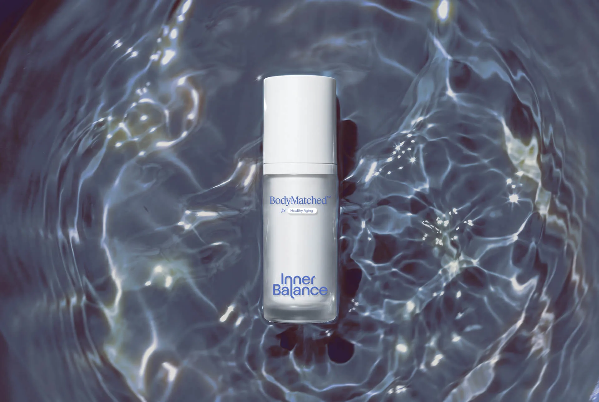 Hand holding a bottle of BodyMatched® face cream