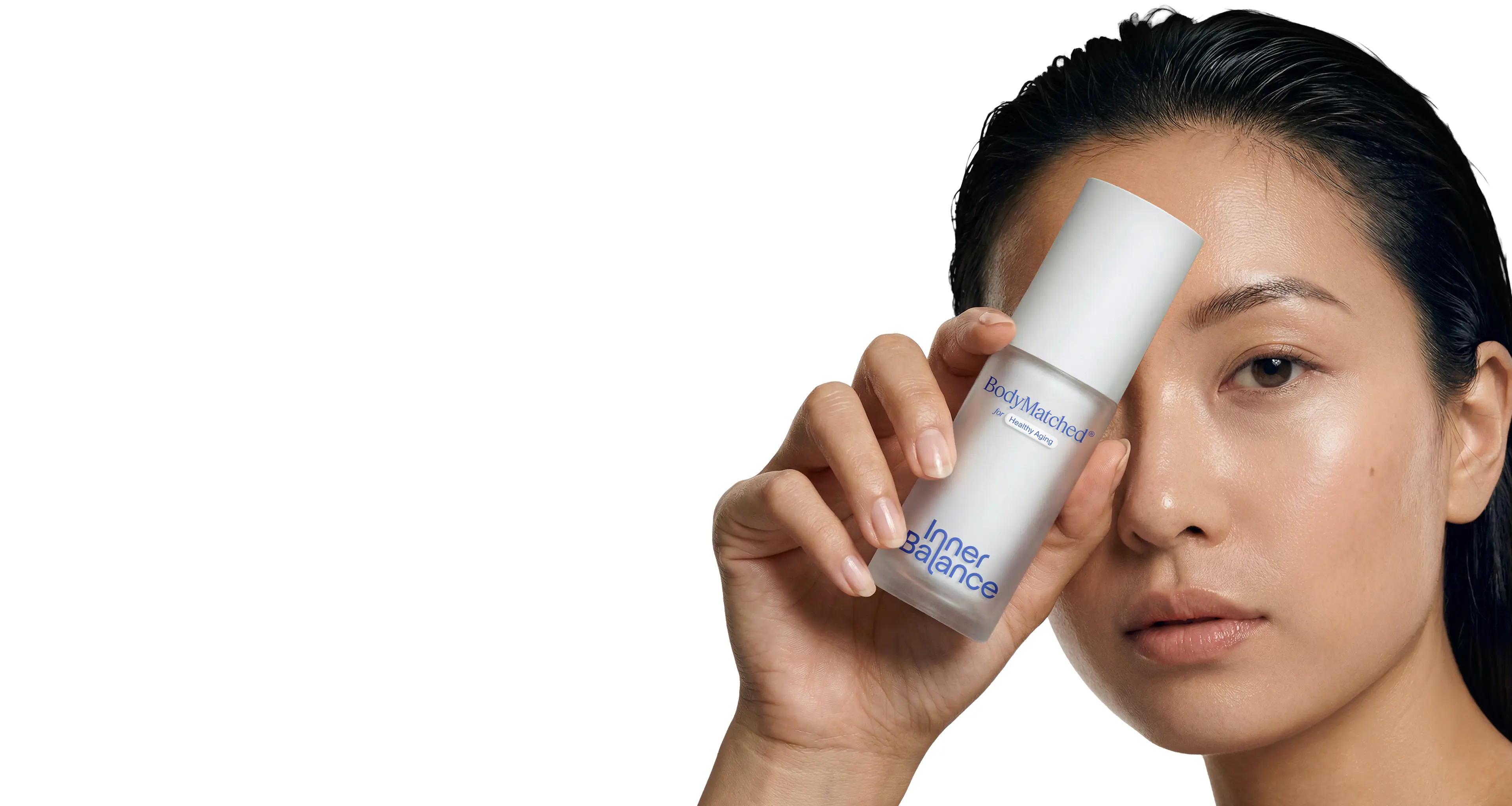Woman holding BodyMatched® niacinamide face cream to her face