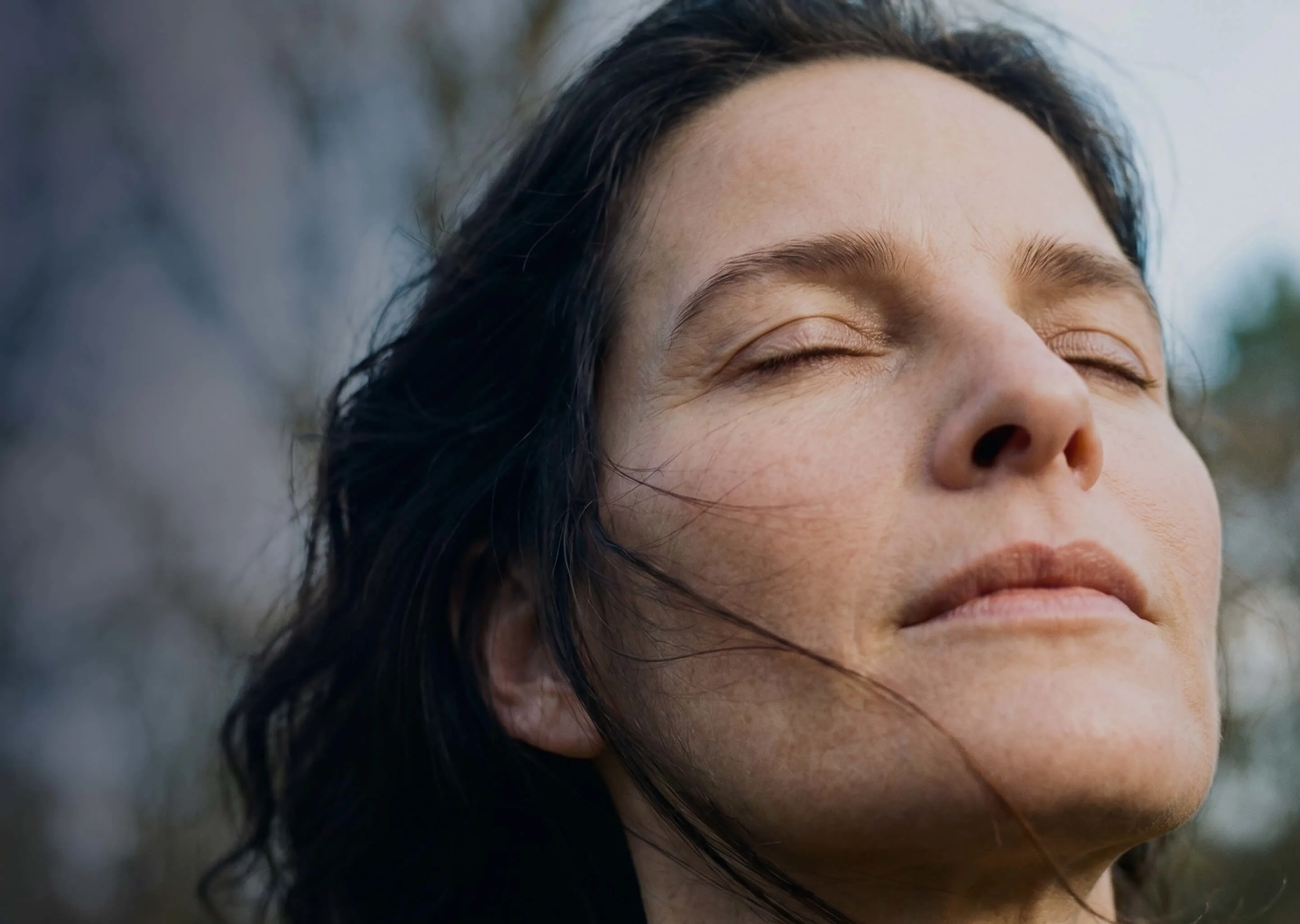Woman experiencing perimenopause symptoms with eyes closed